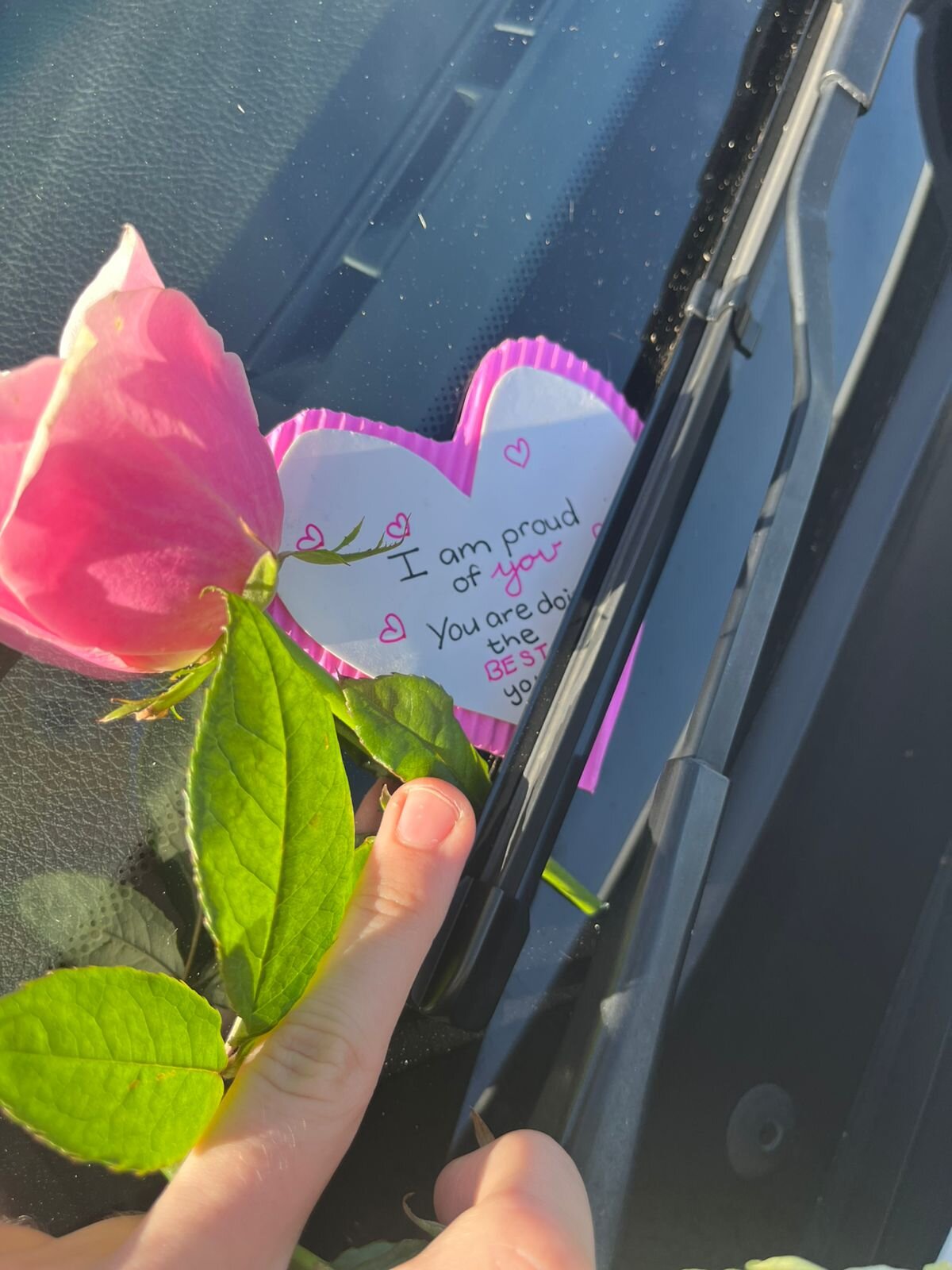 A rose and an encouraging note left on a windscreen