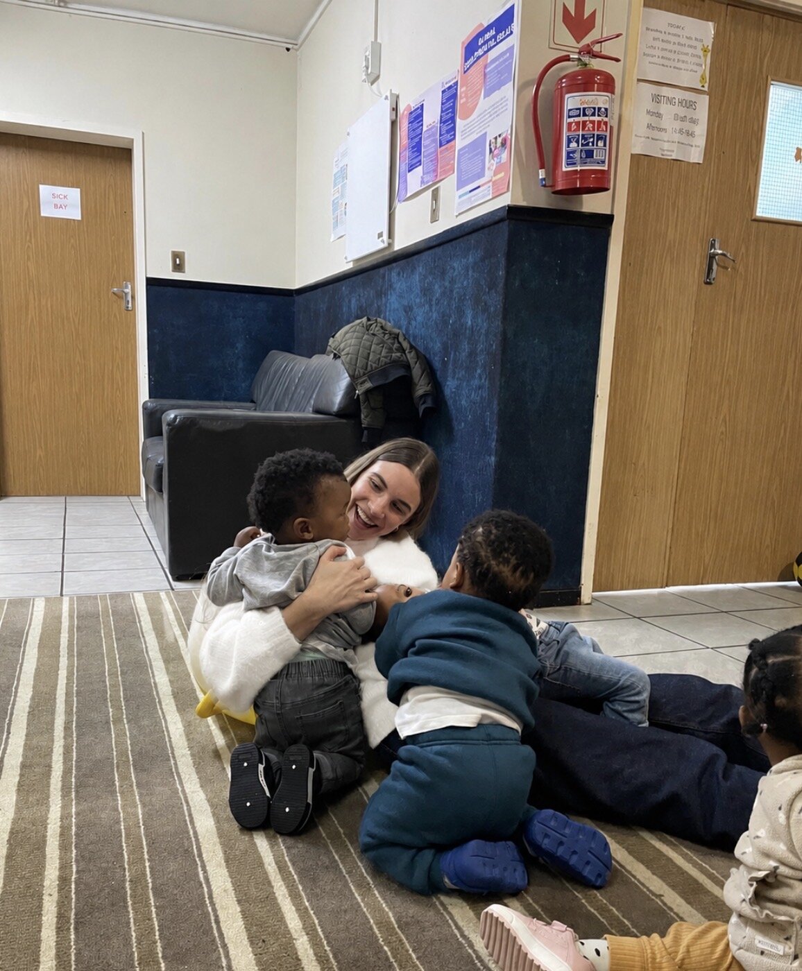 Leah hugging two toddlers at the home